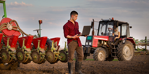 farmer with laptop and tractors